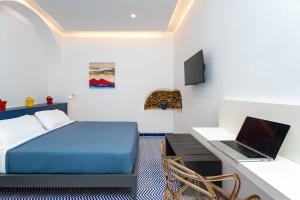 a bedroom with a bed and a desk with a laptop at Domus Pio XI in Sant'Agnello