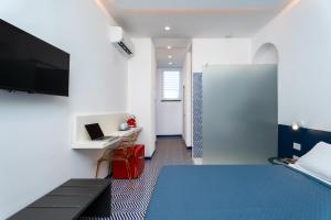 a bedroom with a bed and a desk with a laptop at Domus Pio XI in Sant'Agnello +14 photos