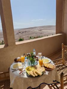 a table with food and a view of the desert at Palais D'escapade in El Karia