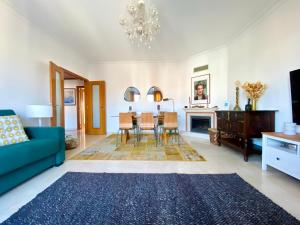 a living room with a blue couch and a dining room at Colinas do Cruzeiro Residence Odivelas in Odivelas
