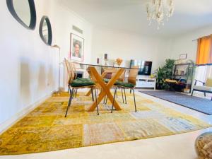 a dining room with a table and chairs on a rug at Colinas do Cruzeiro Residence Odivelas in Odivelas