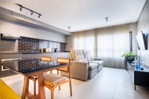 a living room with a table and a couch at Citizen Bueno by Marzani Host in Goiânia