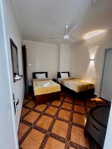a room with two beds and a ceiling at Keylany Hotel Aswan in Aswan