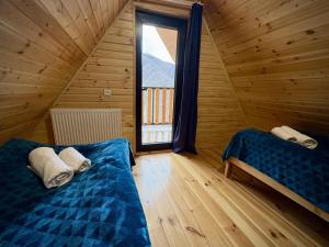 a bedroom with a bed and a window in a log cabin at Kedari Borjomi Cottage in Borjomi