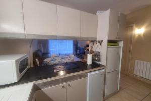 a kitchen with white cabinets and a counter top at 100 m from the beach prime location in Arcachon