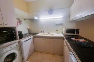a small kitchen with a sink and a microwave at 100 m from the beach prime location in Arcachon