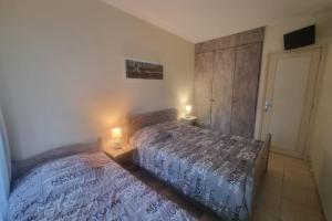a bedroom with two beds and two lamps in it at 100 m from the beach prime location in Arcachon +6 photos