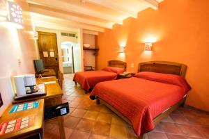 a hotel room with two beds in a room at Hotel Casa Conzatti in Oaxaca City