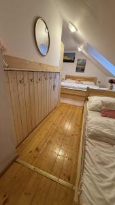 a bedroom with two beds and a mirror on the wall at Chata Buchtovna in Rejdice