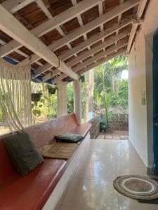 a porch with a red couch on a patio at The Wilderness Studio! in Anjuna