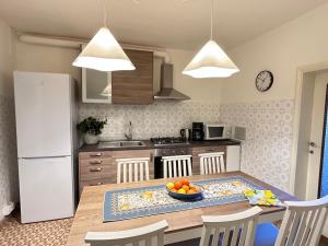 a kitchen with a table with a bowl of fruit on it at Discovering Apartment Pulicchio in Abetone