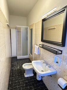 a bathroom with a sink and a toilet and a mirror at Discovering Apartment Pulicchio in Abetone +24 photos