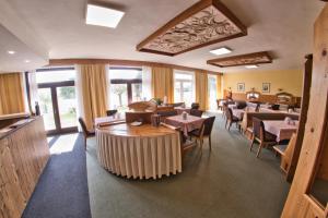 a dining room with tables and chairs and windows at Pension Carinthia in Unterburg am Klopeiner See