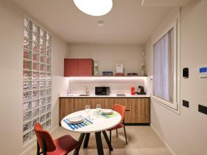 a kitchen and dining room with a table and chairs at Residence Al Centro in Pescantina