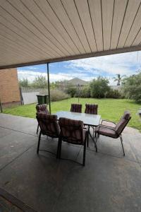 a table and chairs sitting under a roof at 2BR Beachfront Escape in Largs North in Semaphore
