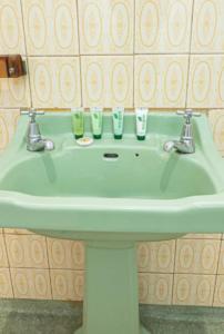 a bathroom sink with three cups on it at 2BR Beachfront Escape in Largs North in Semaphore +8 photos