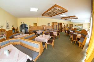 a restaurant with tables and chairs in a room at Pension Carinthia in Unterburg am Klopeiner See