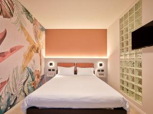 a bed in a room with a painting on the wall at Residence Al Centro in Pescantina