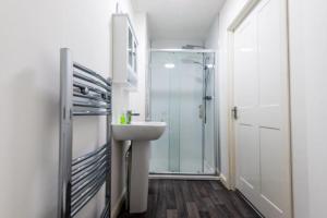 a bathroom with a sink and a glass shower at Josies House - Bright & Cozy Stay in Banff