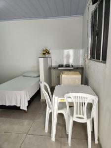 a room with a table and chairs and a bed at Apart hotel in Três Marias
