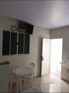 a kitchen with a table and chairs in a room at Apart hotel in Três Marias