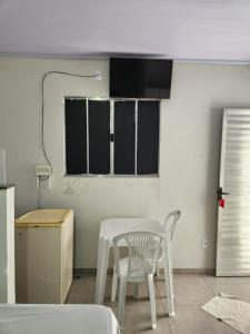 a white table and a white chair in a room at Apart hotel in Três Marias