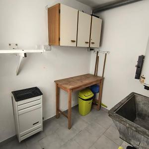 a kitchen with a wooden table and a small desk at Casa VLG 5 pax in Las Grutas