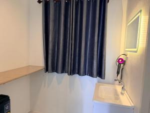 a bathroom with a sink and a blue curtain at ดิโอโซน THE Ozone in Ban Bung Sanan