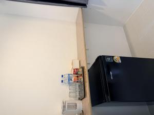 a refrigerator in a room with a phone at ดิโอโซน THE Ozone in Ban Bung Sanan