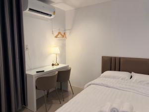 a bedroom with a bed and a desk and a bed at ดิโอโซน THE Ozone in Ban Bung Sanan
