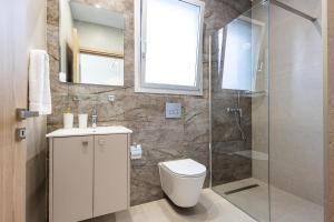 a bathroom with a toilet and a glass shower at Chrystal Residences in Nicosia +52 photos