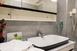 a bathroom with a white toilet and a sink at Le Blanc ApartHotel in Bucharest +79 photos