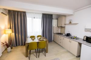 a kitchen with a table and chairs in a room at Le Blanc ApartHotel in Bucharest