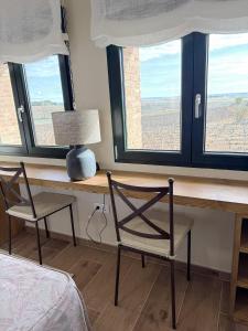 a bedroom with a desk with two chairs and two windows at Alojamiento rural Solterra in Roa +5 photos