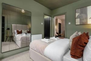 a bedroom with a bed and a couch with a mirror at The Wallace Suite by The Wallace Monument in Stirling