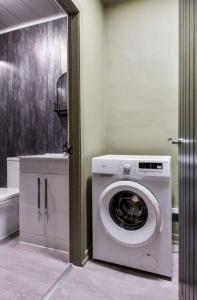a washing machine in a bathroom with a sink at The Wallace Suite by The Wallace Monument in Stirling