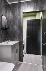 a bathroom with a sink and a black door at The Wallace Suite by The Wallace Monument in Stirling +18 photos