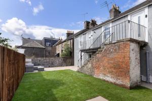 a courtyard of a house with a grass yard at The Wallace Suite by The Wallace Monument in Stirling