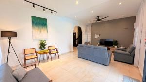a living room with a couch and a tv at A6886 Swimming Pool Villa in Kuantan