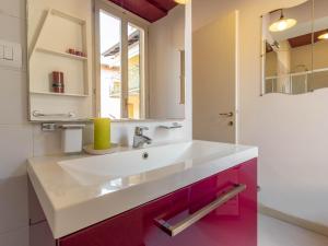 a bathroom with a white sink and pink cabinets at Lovely Home Apartment in Lecco +22 photos