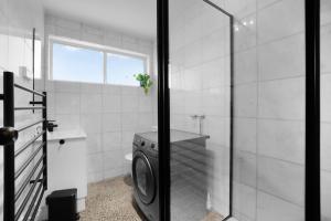 a bathroom with a washing machine next to a toilet at Sunshine Family Sophistication in Albion +14 photos