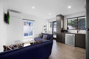 a living room with a blue couch and a kitchen at Sunshine Family Sophistication in Albion