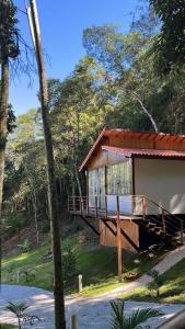 a house with a deck in the woods at Cabana Dream Garden in Nova Friburgo