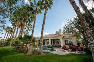 a house with palm trees and a pool at The Fourteen at PGA West in La Quinta