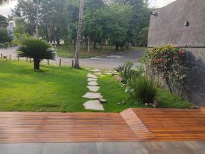 a garden with a wooden bench and a walkway at jaó, mazzahome in Goiânia