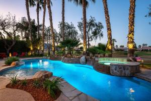 a swimming pool with palm trees in a resort at The Fourteen at PGA West in La Quinta