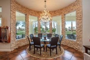 a dining room with a table and chairs and a chandelier at The Fourteen at PGA West in La Quinta
