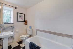 a bathroom with a tub and a toilet and a sink at 2 Bed in Hawes oc-c33371 in Hawes +20 photos