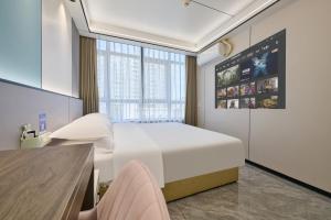 a bedroom with a white bed and a large window at Four Seasons Clouds Xiamen North Railway Station Store in Xiamen +26 photos