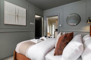 a bedroom with a bed with white pillows and a mirror at Caledonia Suite by The Wallace Monument in Stirling